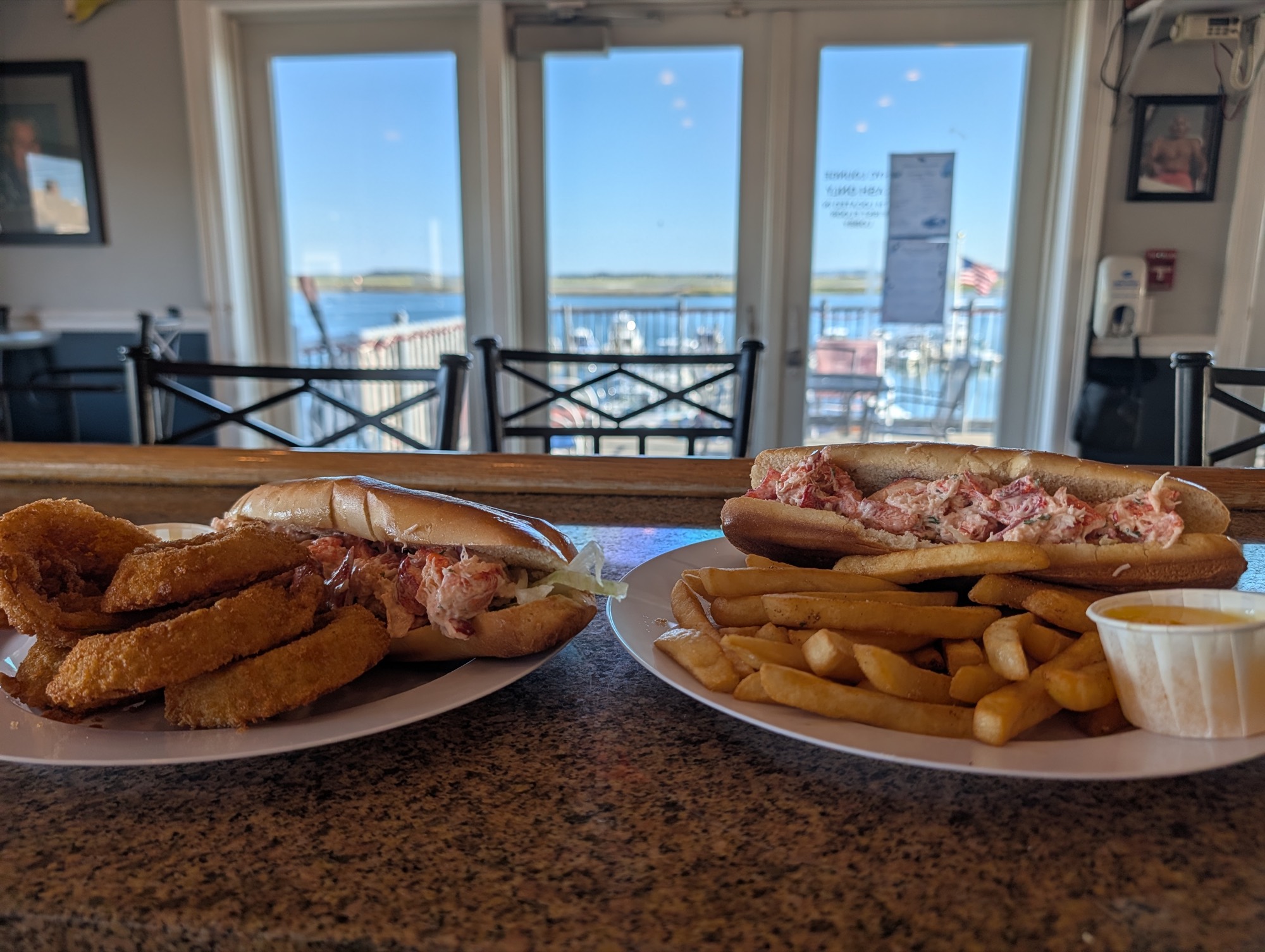 Lobster rolls from Jose's Kitchen on the bar, harbor beyond the doors
